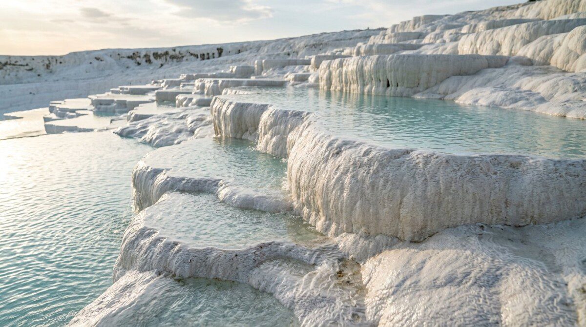 Close-up of Pamukkale white travertine layered terraces and turquoise pools showing geological formation